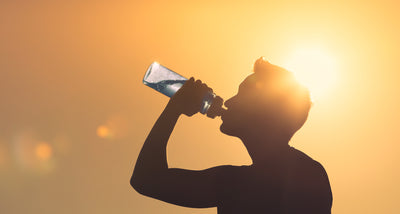 Sun in Background Person Outside Drinking Water From a Reusable Bottle