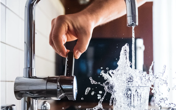 Hand turning on faucet